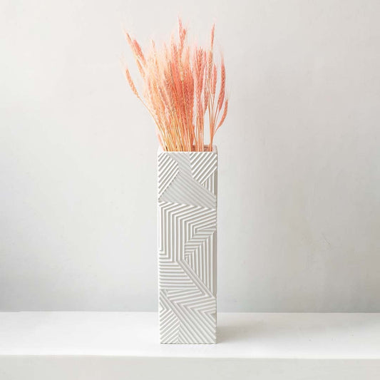 Dried pink pampas grass arranged in a white patterned vase creating a vibrant fluffy pampas décor accent perfect for boho home décor modern styling and artistic interior decoration.