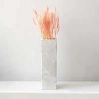 Dried pink pampas grass arranged in a white patterned vase creating a vibrant fluffy pampas décor accent perfect for boho home décor modern styling and artistic interior decoration.
