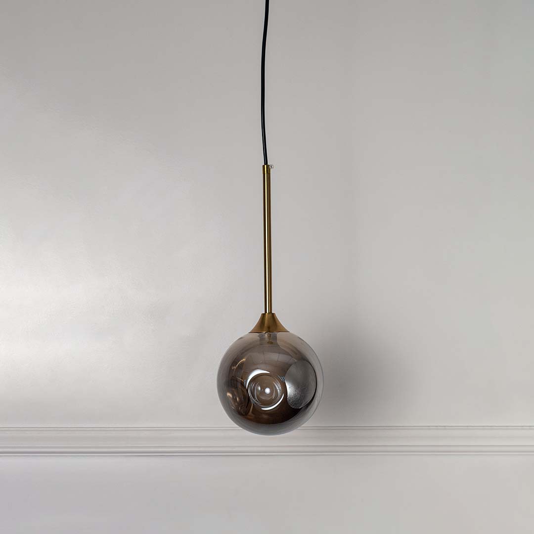 Black circular frame wall light with clear glass shade and exposed bulb shown off on white background for modern interiors.