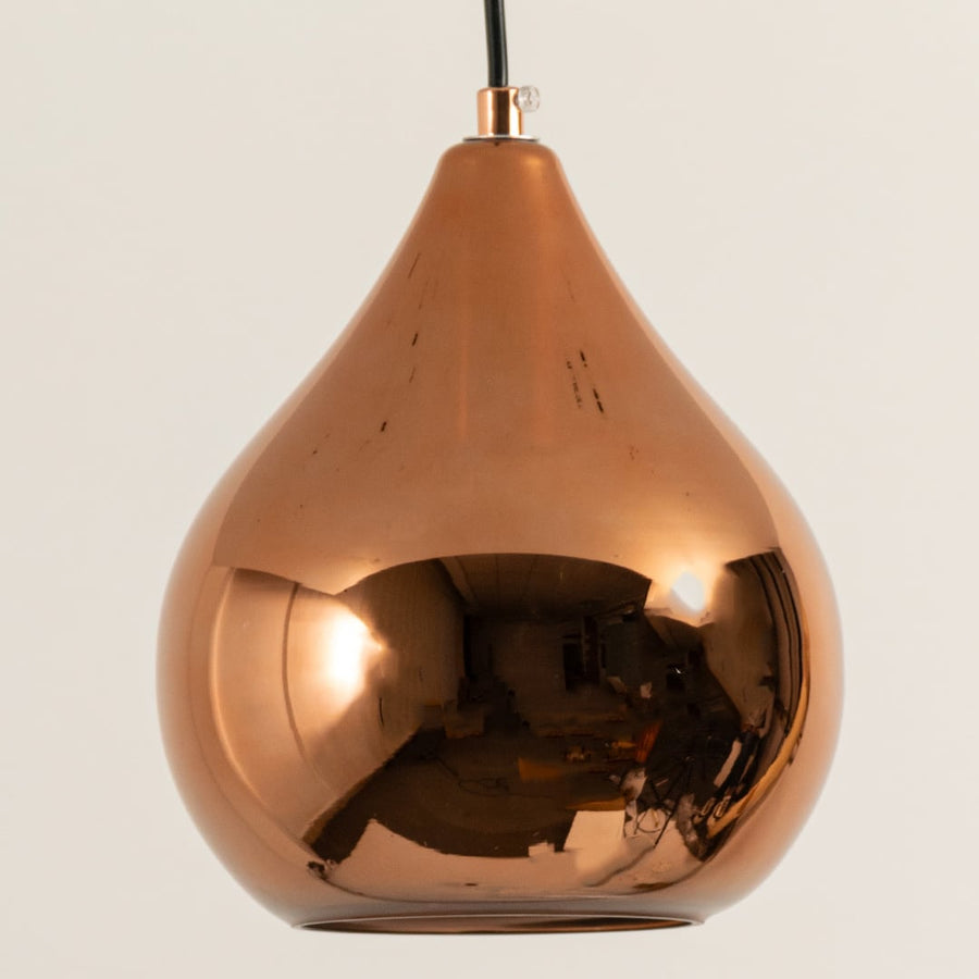 Copper finish metal pendant light closeup showing reflective surface smooth curves and premium build suited for kitchen island or dining decor.