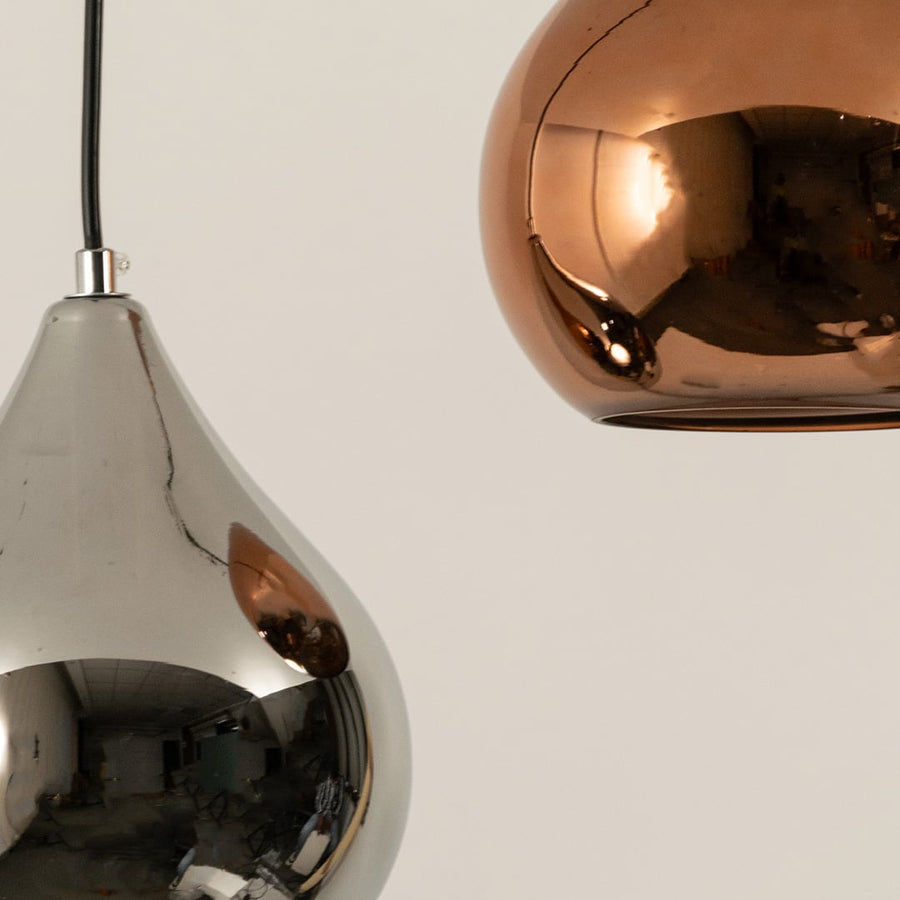 Closeup view of copper metal pendant lights highlighting smooth reflective surface premium finish and sculpted form.