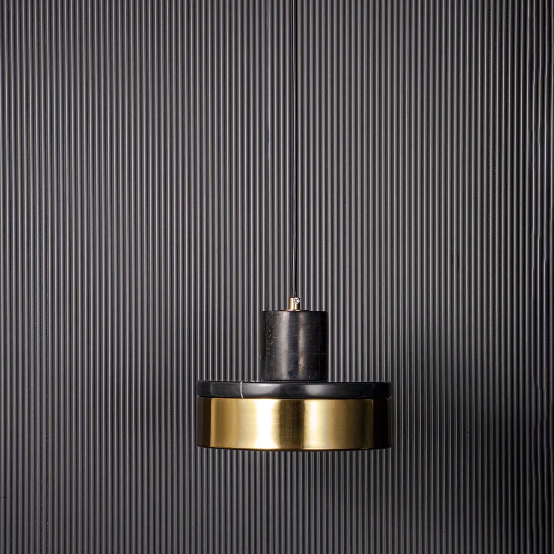 Modern pendant light with black metal shade and gold accent shown unlit on black background for bold contemporary ceiling decor.