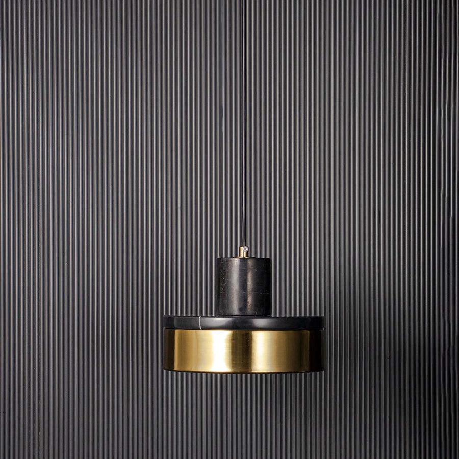 Modern pendant light with black metal shade and gold accent shown unlit on black background for bold contemporary ceiling decor.