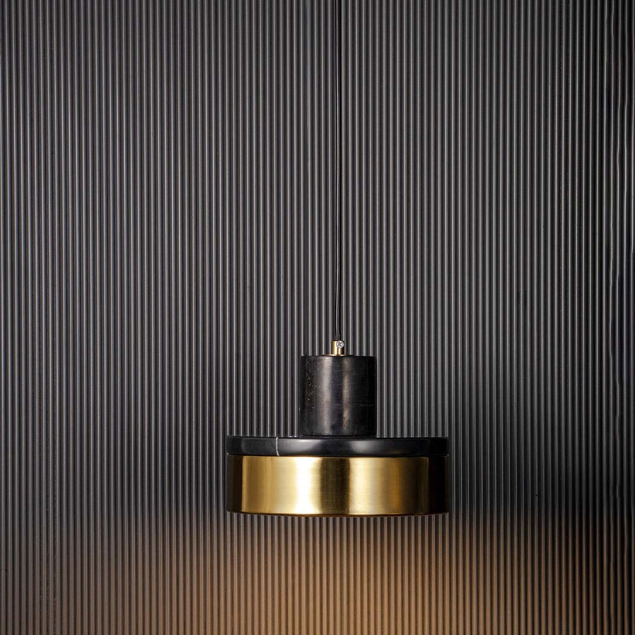 Modern black and golden round pendant lamp glowing with warm light stylish ceiling light fixture for luxury bedroom and dining.