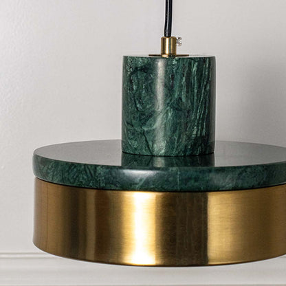 Closeup of pendant lamp with polished green marble and golden shade highlighting premium material and contemporary design.
