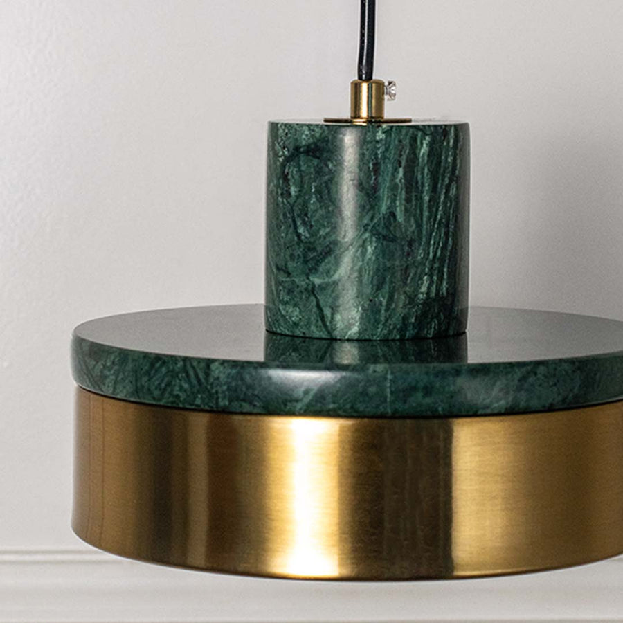 Closeup of pendant lamp with polished green marble and golden shade highlighting premium material and contemporary design.