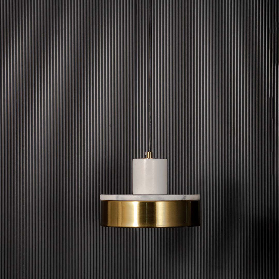 Elegant pendant light with white marble detail and gold base shade displayed off on black background for modern interiors.
