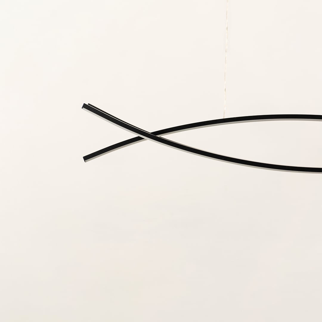 A sleek black linear chandelier with two intersecting curved bars displayed on a clean white backdrop with the light off offering minimal refined modern décor.