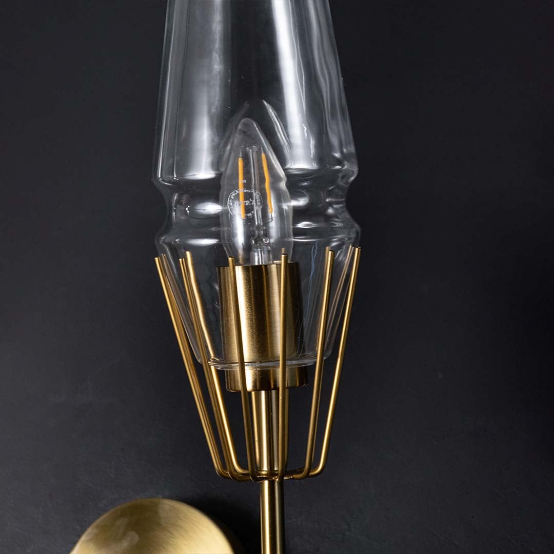 Detailed view of polished gold brass metal cage frame and tapered glass of modern double wall lamp showing high quality craftsmanship.