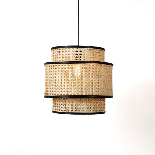 Three tier rattan pendant light glowing softly against white background ideal for modern home and cafe decor.
