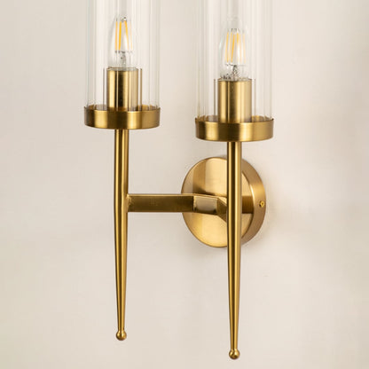 Closeup view of the double glass wall light displaying the transparent cylindrical shade and warm glowing filament bulb through the detailed glass.