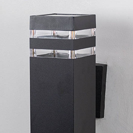 Closeup of rectangular black wall light featuring layered acrylic accents and smooth matte surface.