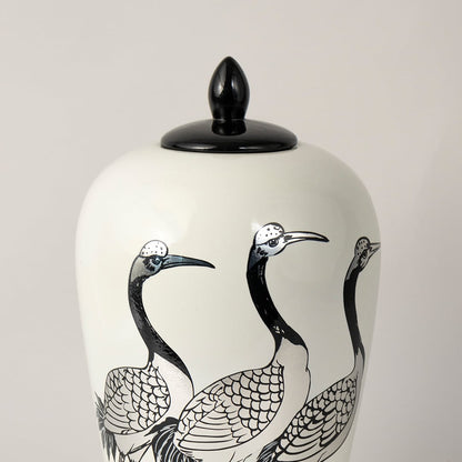 White ceramic decorative jar with black crane artwork and black lid for elegant shelf styling and modern home decor.