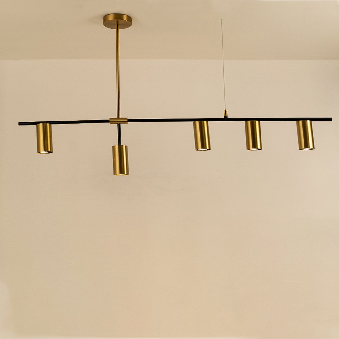 Sleek gold linear chandelier illuminated on white background showcasing minimalist design perfect for dining tables and modern interiors.