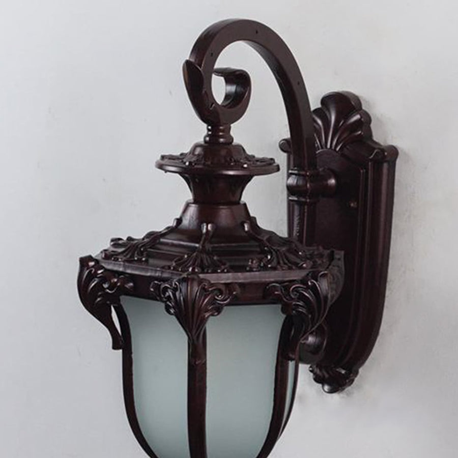 Closeup of vintage outdoor wall lantern in bronze metal with frosted glass shade for exterior lighting.