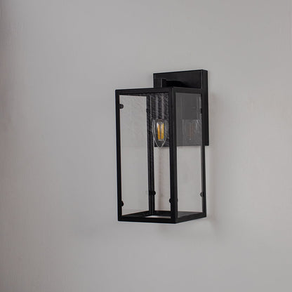 Black rectangular wall lantern with clear glass panels and exposed bulb shown off on white background for modern home decor.