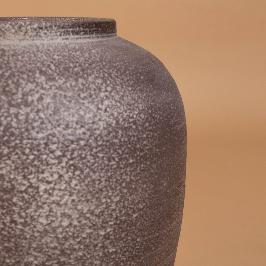 Closeup of brown rustic tall decorative vase showing detailed weathered texture and sculpted shape ideal for artistic modern home decor.