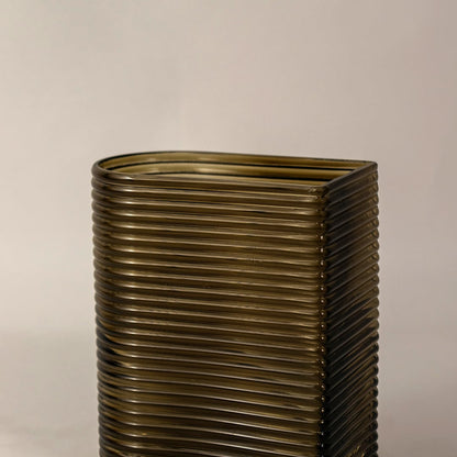 Closeup of ribbed glass vase in smoke brown finish showing curved rectangular shape and fine textured details for stylish placement.