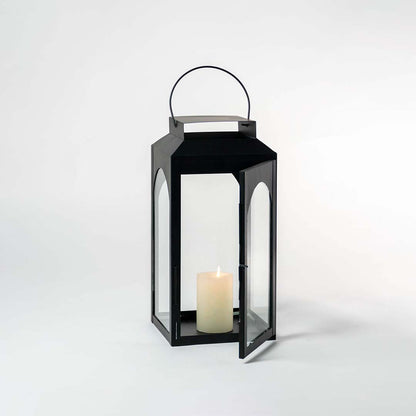 Black metal outdoor lantern candle holder with clear glass panels for tabletop decor and patio styling use.