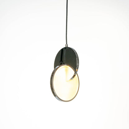 Luna disc pendant light turned on with circular diffused glow and black metallic accent against white background.