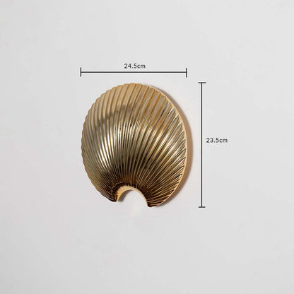A gold shell decor accent shown with measurements displaying 24.5 cm width and 23.5 cm height offering a clear understanding of the overall size.