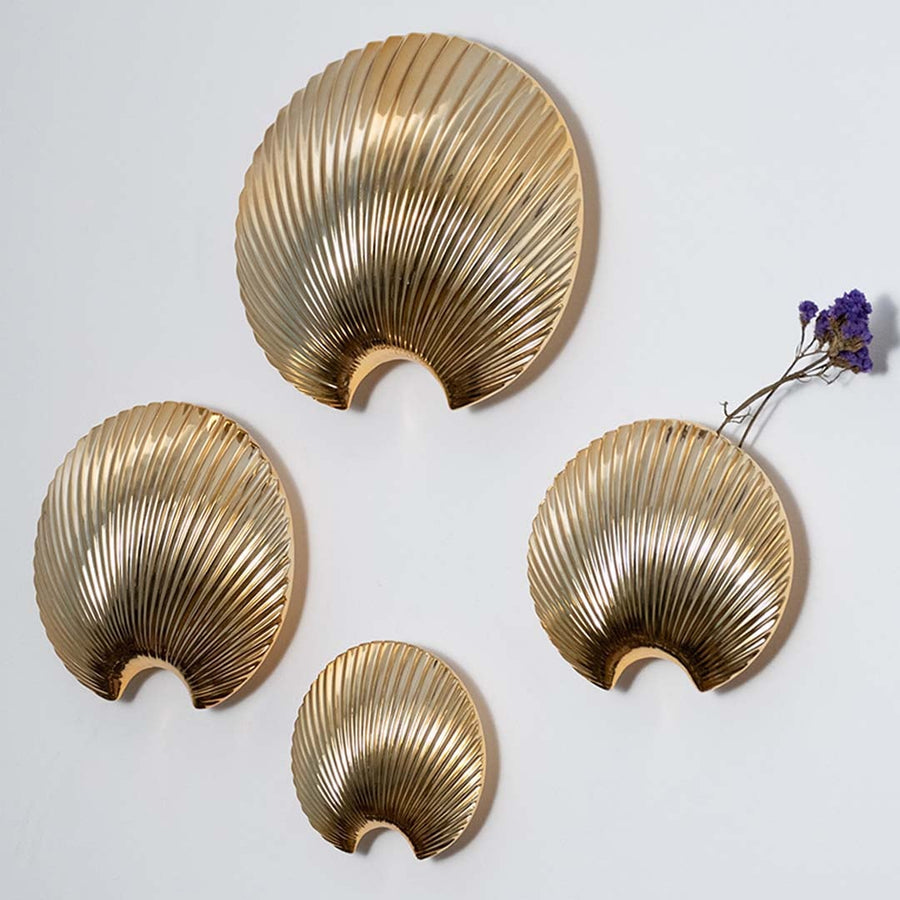 A gold shell decorative accent shown in a clean minimal setup highlighting its curved ridged texture and modern sculptural design for home styling.