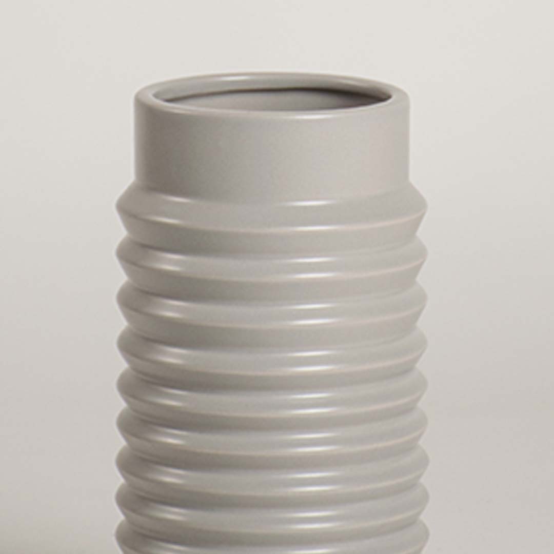 Closeup of light grey ribbed ceramic vase highlighting its smooth glossy finish and textured detailing ideal for modern home styling.