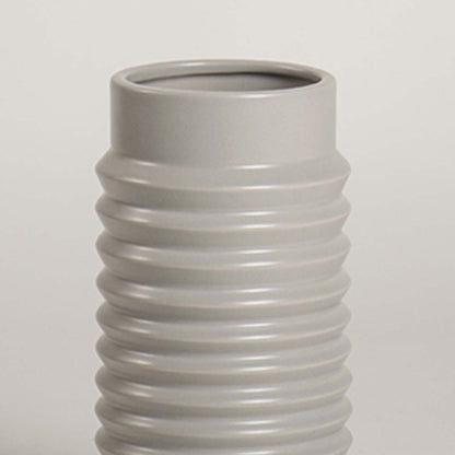 Closeup of light grey ribbed ceramic vase highlighting its smooth glossy finish and textured detailing ideal for modern home styling.