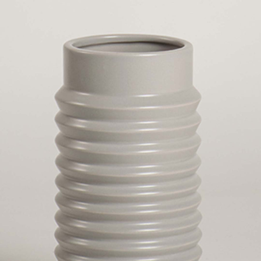 Closeup of light grey ribbed ceramic vase highlighting its smooth glossy finish and textured detailing ideal for modern home styling.
