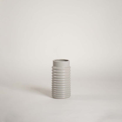 Modern light grey ceramic vase with ribbed design displayed on a white background ideal for minimalist decor and tabletop styling.
