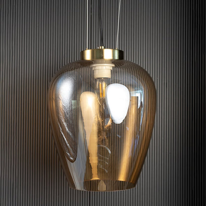 Amber glass pendant light unlit against black background showcasing soft amber tone and reflective finish.