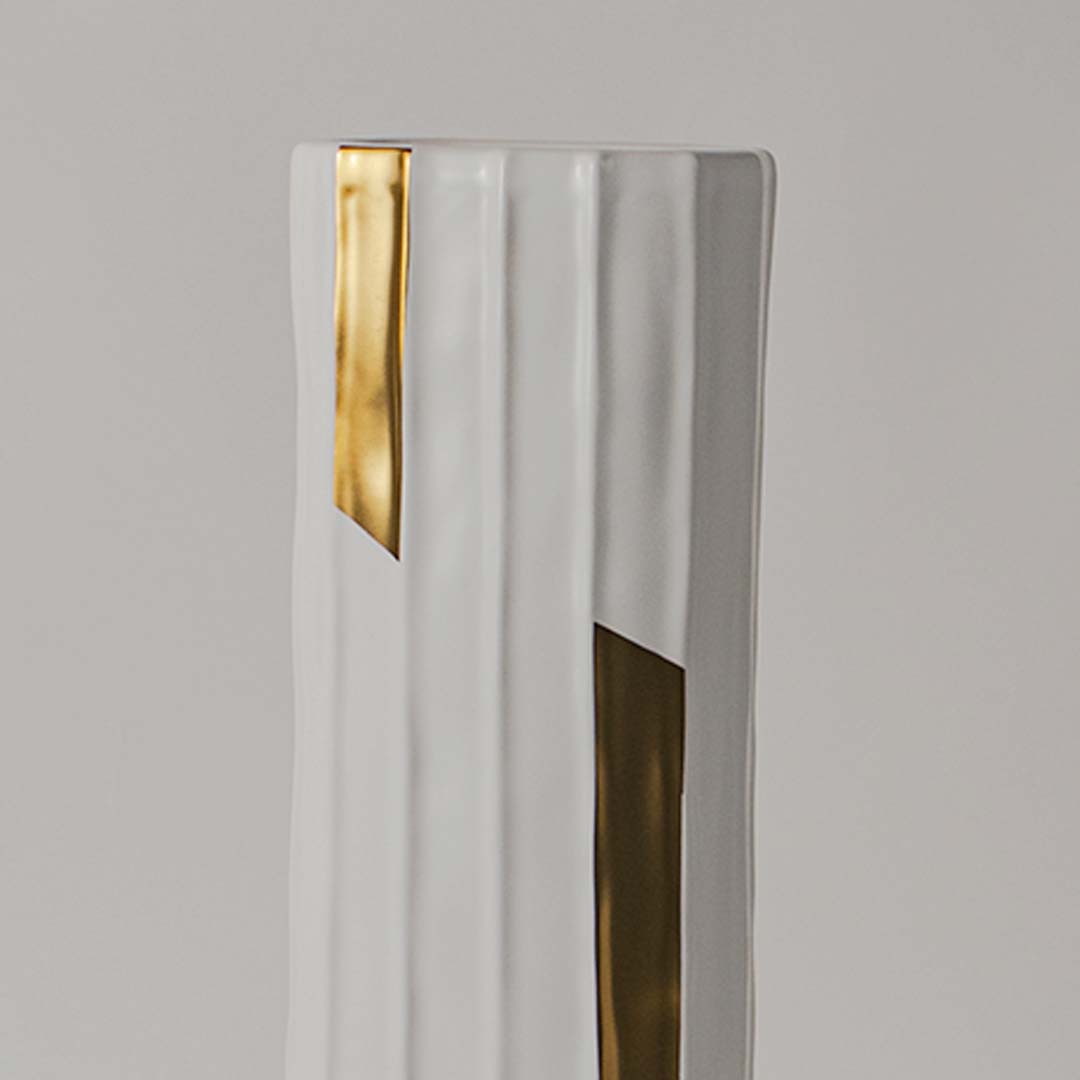 Closeup view of the tall ribbed vase with gold detailing showing the smooth finish and geometric accents that enhance its stylish decorative appeal.