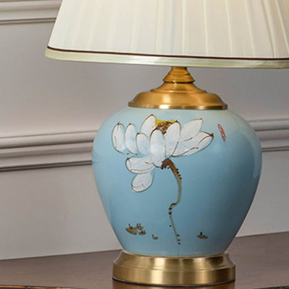 Closeup of Lotus lamp highlighting blue ceramic base with hand-painted floral design and pleated shade.