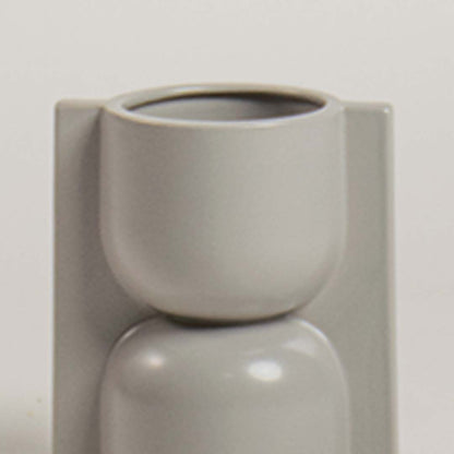Closeup of light grey geometric ceramic vase showing its smooth glossy finish and sculptural form ideal for modern artistic decor.