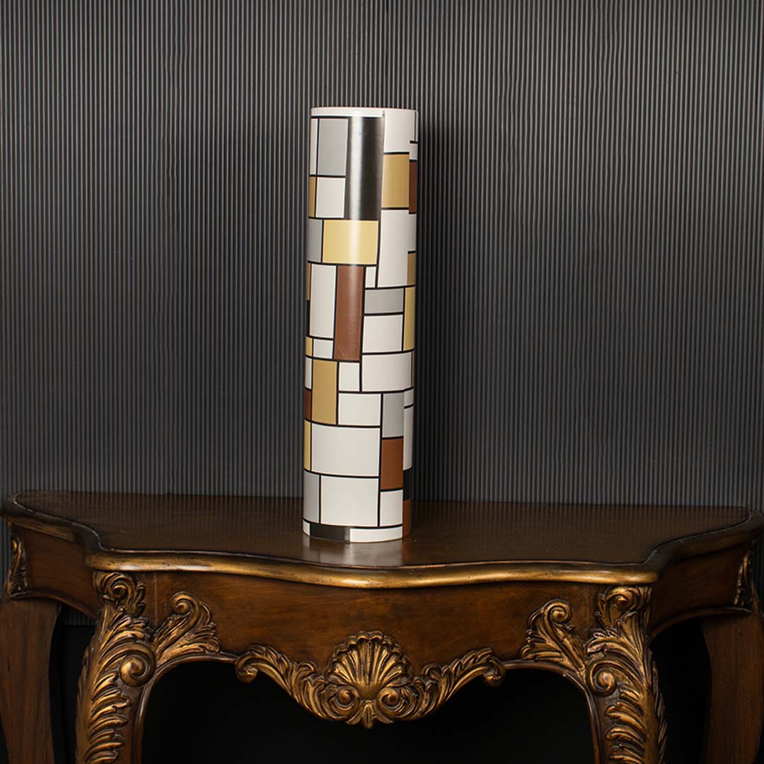 Tall geometric multicolor ceramic vase on a dark black background enhancing its bold artistic block pattern ideal for modern interior styling.