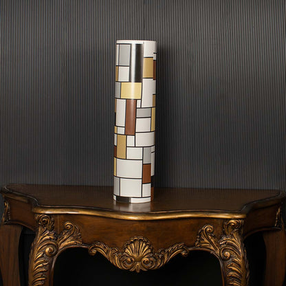 Tall geometric multicolor ceramic vase on a dark black background enhancing its bold artistic block pattern ideal for modern interior styling.