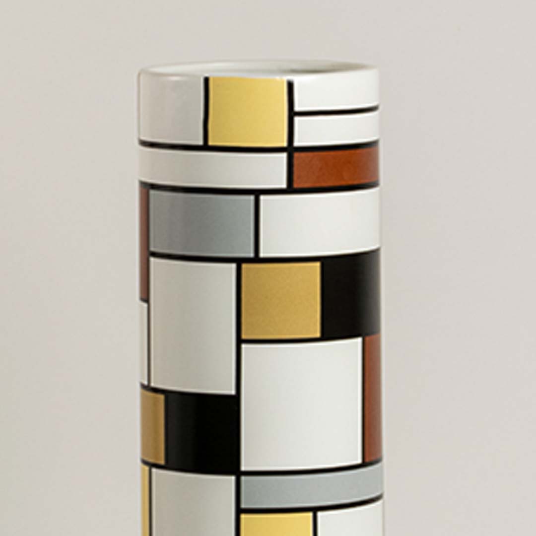 Closeup of geometric ceramic vase showing detailed block pattern and textured colors creating a bold artistic accent for contemporary decor.