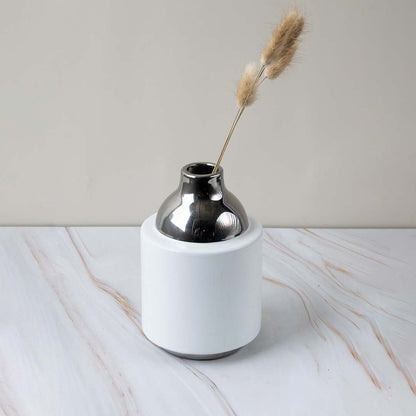 White ceramic decorative vasewith silver metal lid styled on surface highlighting minimal design glossy texture and refined decor placement for homes.