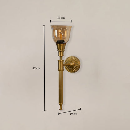 Traditional brass wall sconce with amber glass measuring 47cm height 13cm shade width and 19cm projection from wall mount.