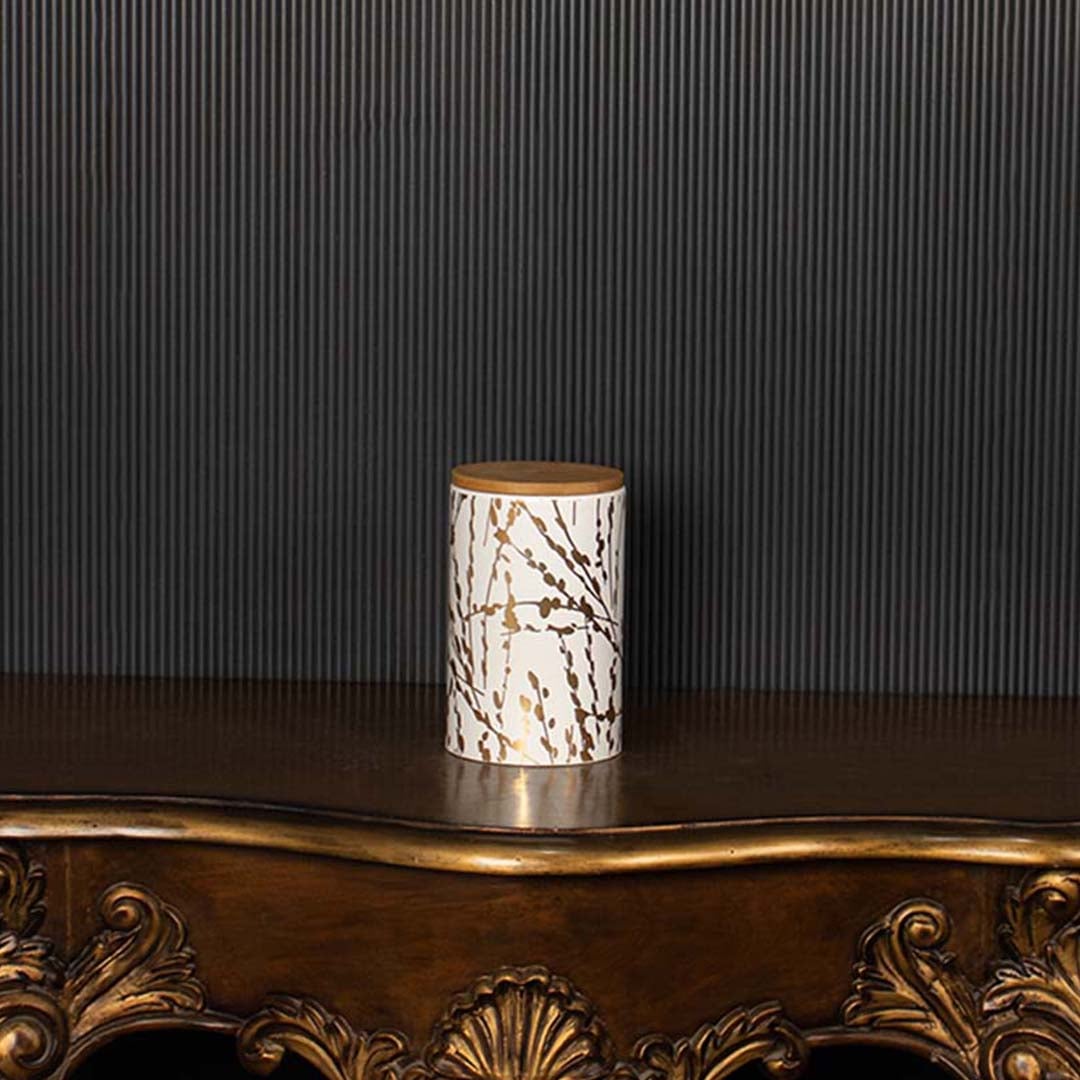 Decorative ceramic jar with golden botanical detailing and a wooden lid shown clearly for product focus against a crisp contrasting backdrop.