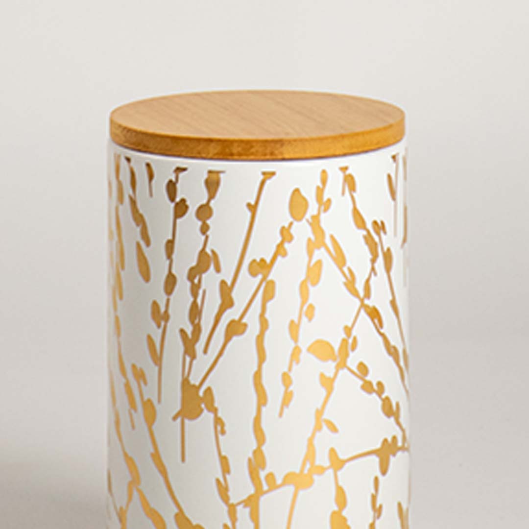 Closeup view of a ceramic jar with a golden botanical design and smooth wooden lid  showcasing its texture  detailing  and clean finish.