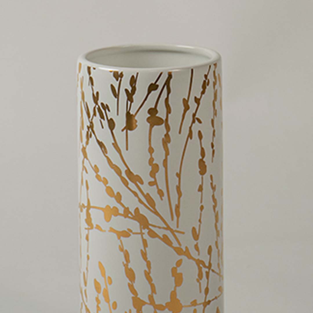 Closeup of the tall white vase highlighting its textured vertical ridges and bold gold accent panels for a refined and elegant modern decor look.