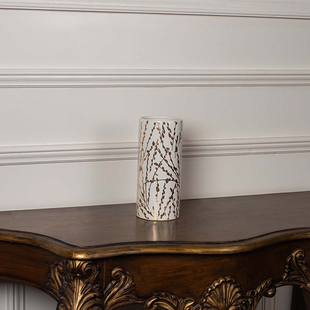 Tall white vase with ribbed detailing and gold geometric accents placed on a clean white background showcasing its minimal modern aesthetic.