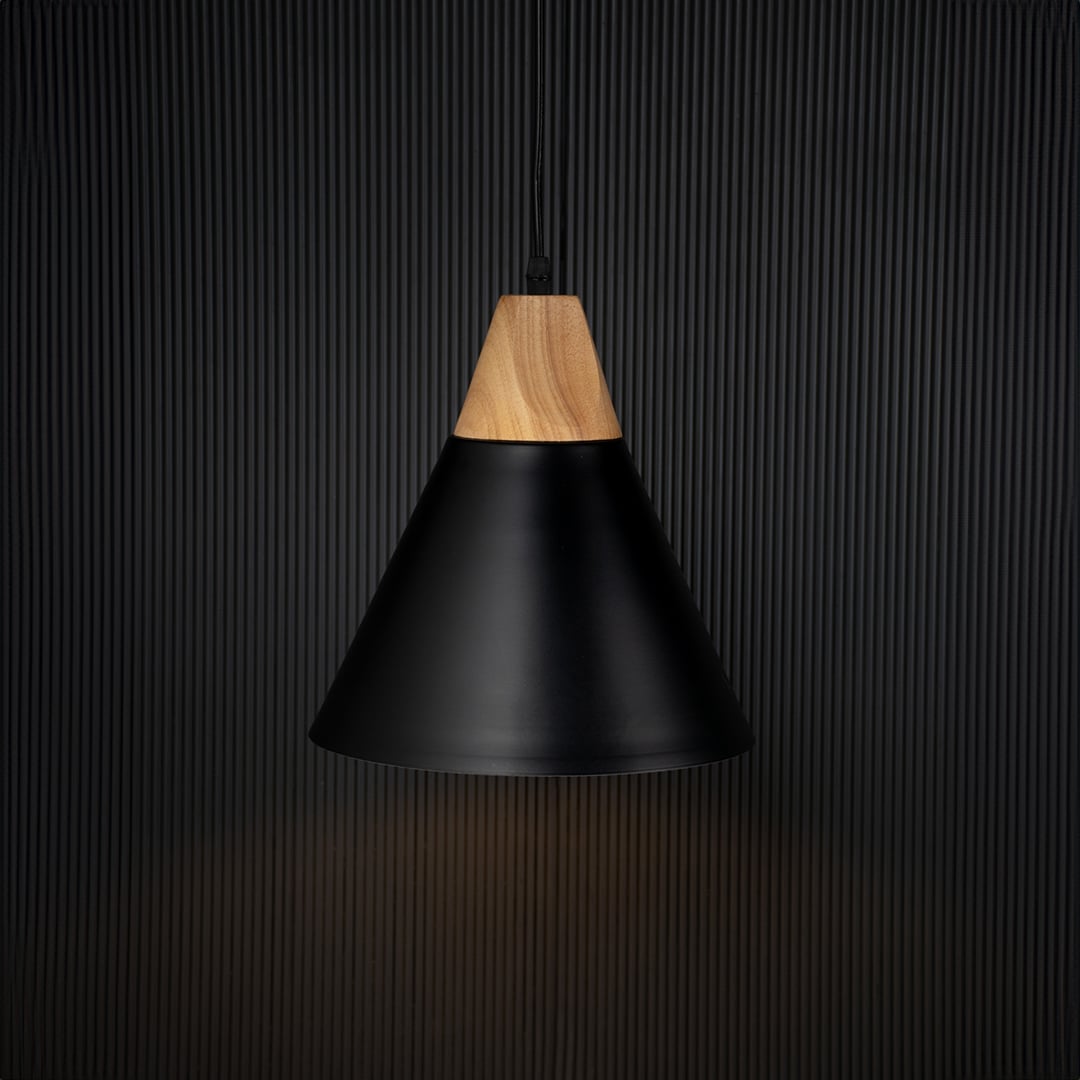 Modern black pendant light with wood top illuminated on back background for elegant dining or kitchen ceiling decor.
