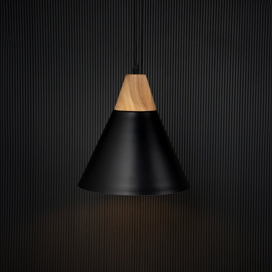 Modern black pendant light with wood top illuminated on back background for elegant dining or kitchen ceiling decor.