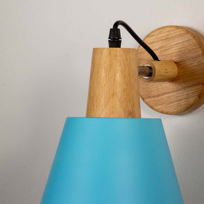 Closeup of wall lamp with matte sky blue metal shade wooden base and black cord showcasing stylish modern wall lighting.