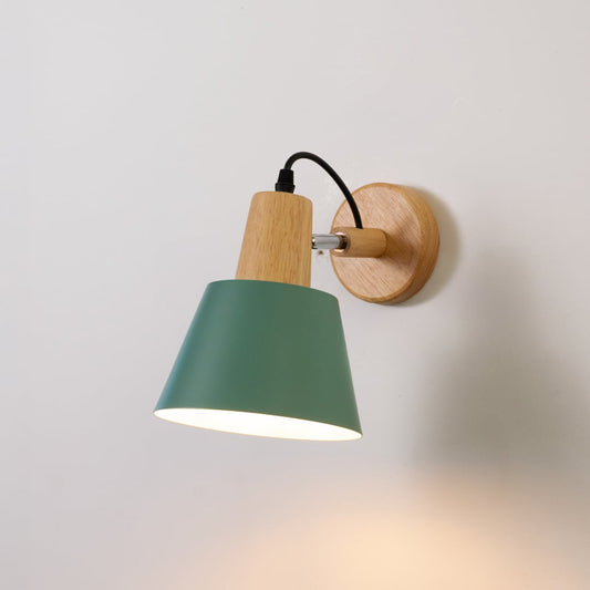 Wall light glowing with matte dark green shade wooden base and black cord creating soft warm illumination for elegant interiors.