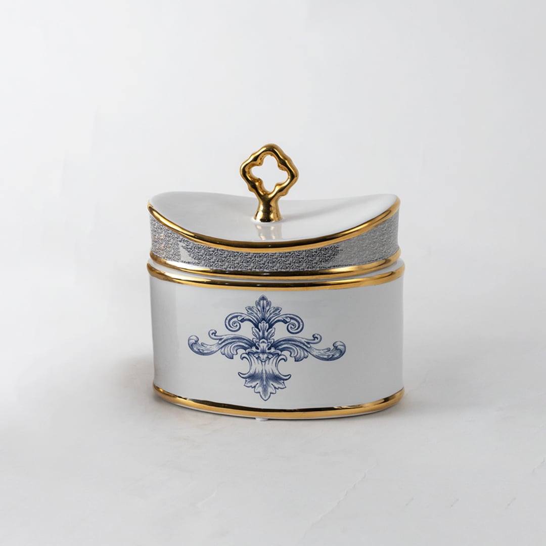 White ceramic jar with gold lid and blue artwork in a front view ideal for luxury décor styling and premium tabletop accents.