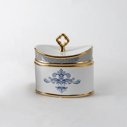 White ceramic jar with gold lid and blue artwork in a front view ideal for luxury décor styling and premium tabletop accents.