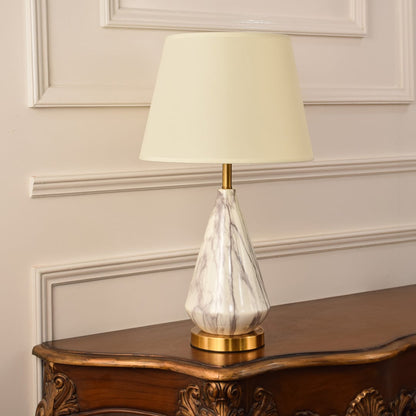 Minimalist marble table lamp with gold metal accents and a fabric shade maintaining elegance even when unlit suitable for classic or modern decor.